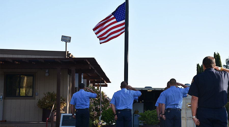 Fire fighters saluting flag